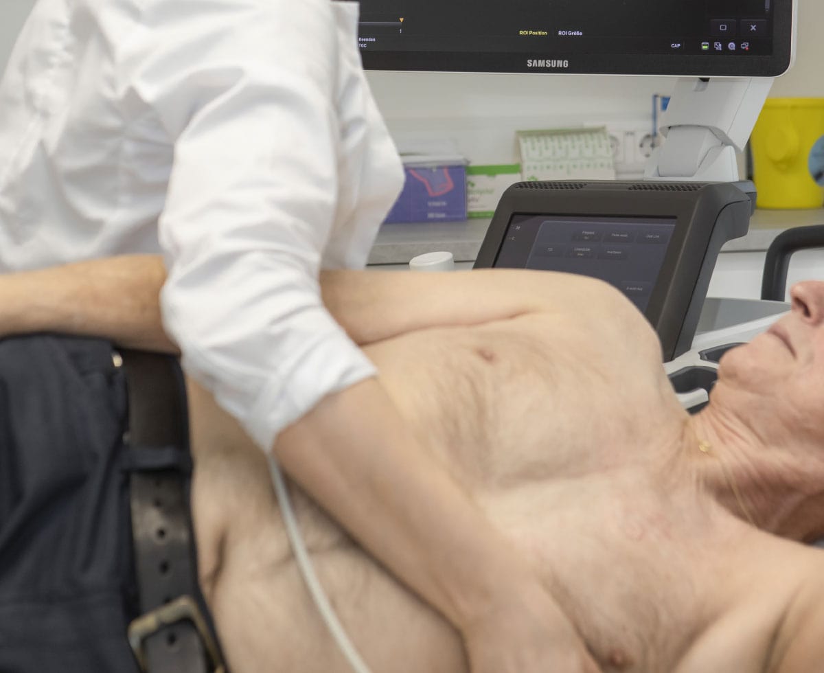 Dr. Dissauer führt einen Ultraschall bei einem älteren Mann durch